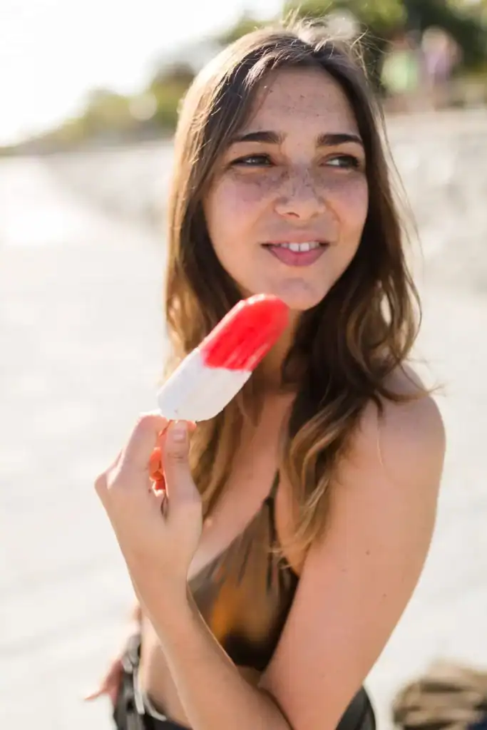 Woman holding a white and red popsicle